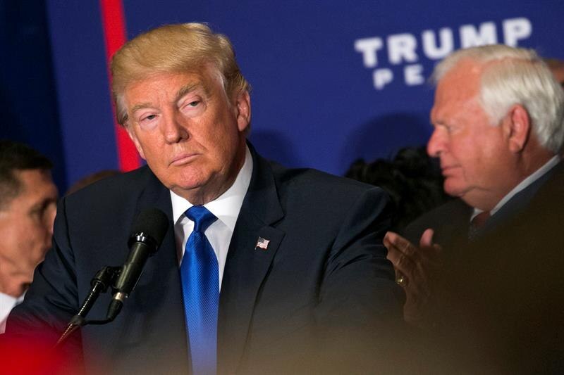 El presidente Donald Trump escucha un discurso durante un evento de campaña.