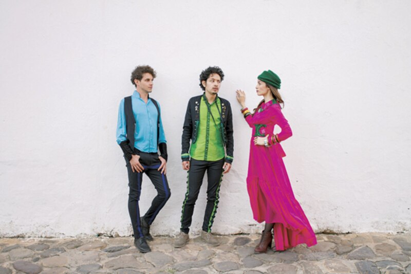Tres personas con ropa colorida posando para una foto