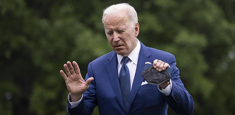 El presidente Biden sostiene una mascarilla en la mano