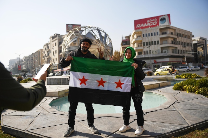 Damascus (Syrian Arab Republic), 09/12/2024.- Syrians pose with the opposition flag on a street in Damascus, Syria, 09 December 2024. Syrian rebels entered Damascus on 08 December 2024 and announced in a televised statement the 'Liberation of the city of Damascus and the overthrow of Bashar al-Assad', as well as the release of all the prisoners. (Siria, Damasco) EFE/EPA/HASAN BELAL