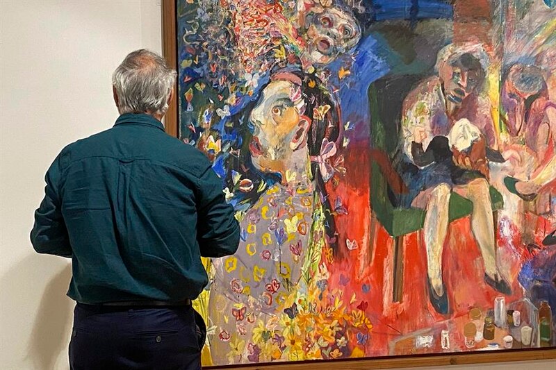 Un hombre mirando una pintura