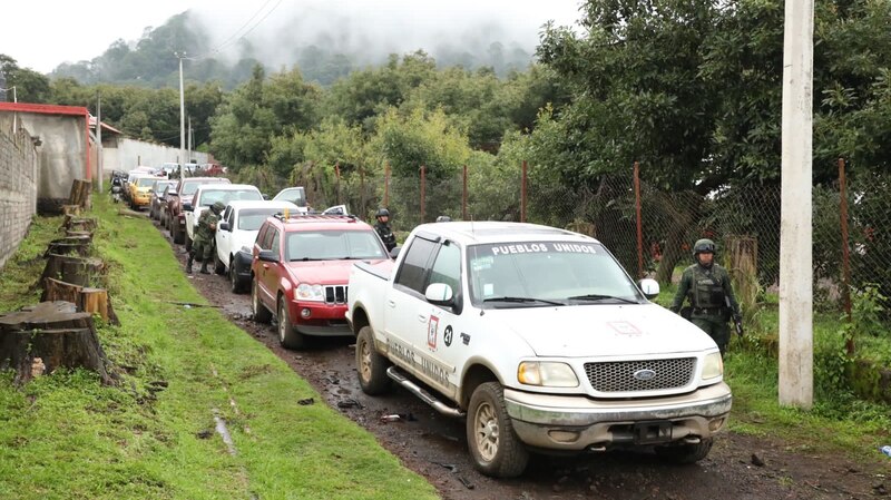 Camionetas blancas en un camino de terracería