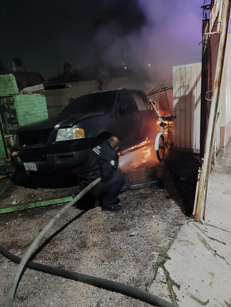 Bombero apaga incendio en una camioneta