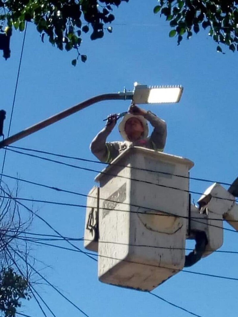 Un trabajador arregla una farola
