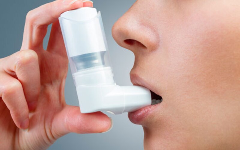 Mujer usando un inhalador para el asma