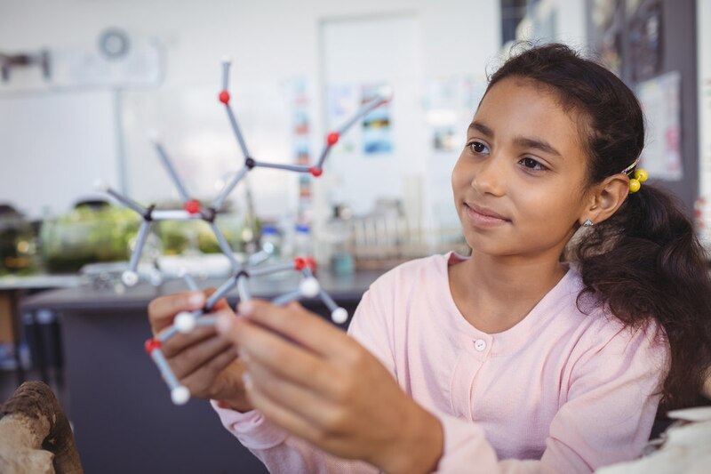 Alumna sosteniendo un modelo molecular