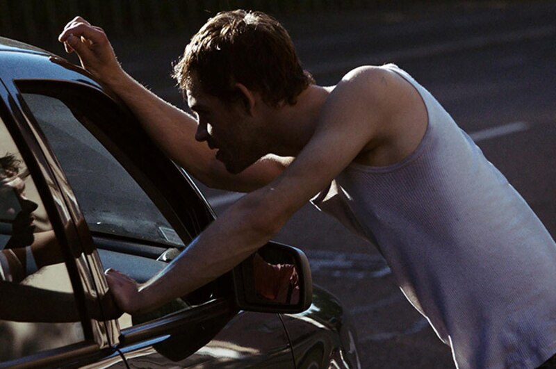 Un hombre mirando dentro de un coche