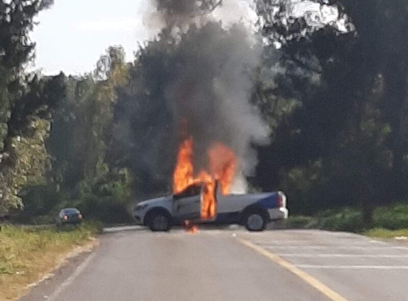 Camioneta policial incendiada en la carretera