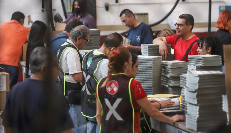 Trabajadores de una imprenta preparando libros para su distribución