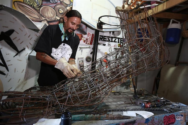 Artista soldando una escultura de metal