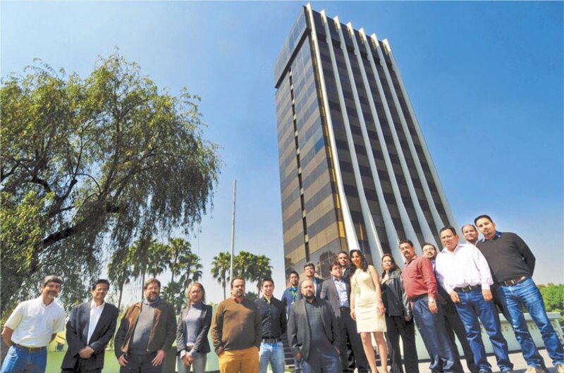Políticos mexicanos posando frente a un edificio alto