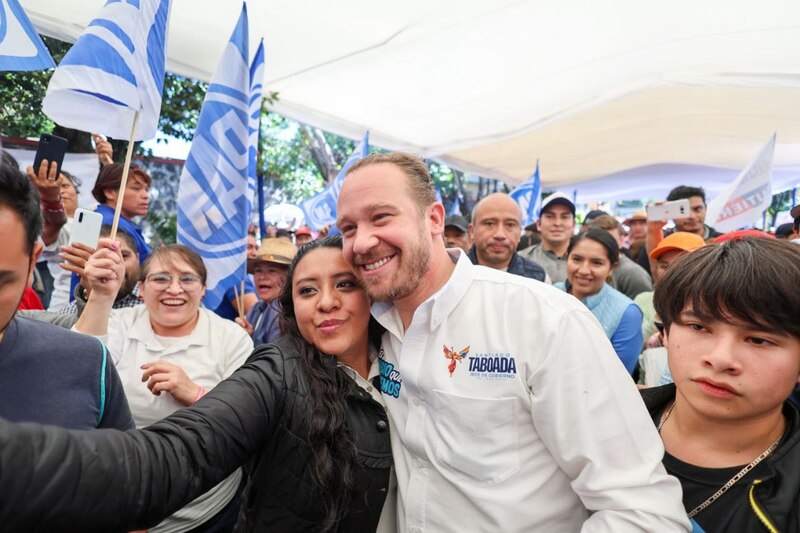 El candidato a gobernador de Nuevo León, Samuel García, se toma una foto con una mujer durante un evento de campaña.