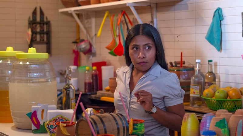 Mujer preparando bebidas en un mercado mexicano