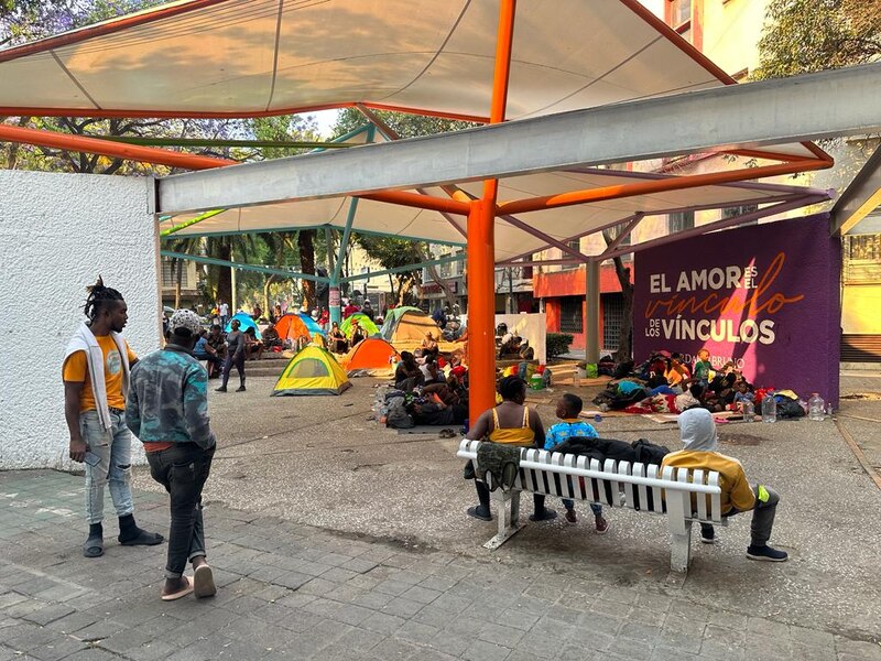 Un grupo de personas sin hogar descansa en un parque de la ciudad.