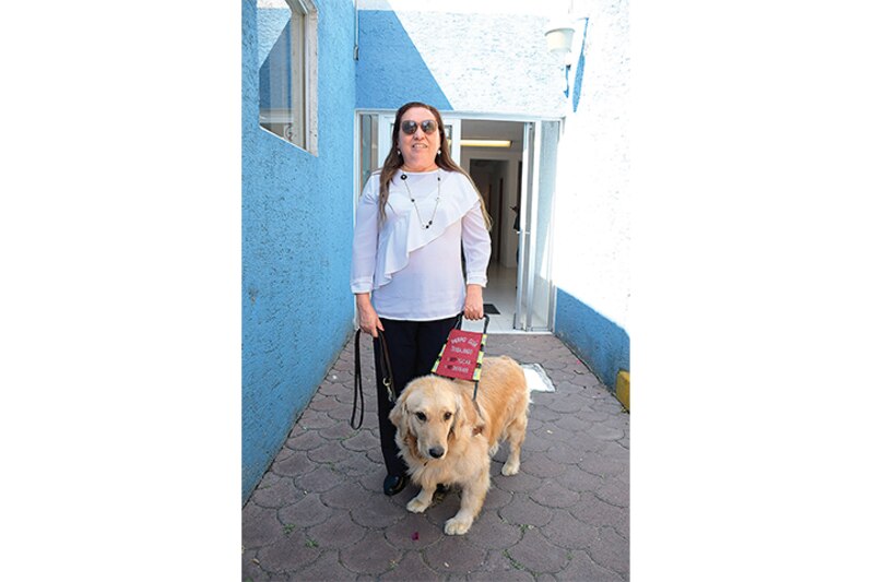 Mujer con discapacidad visual camina con su perro guía