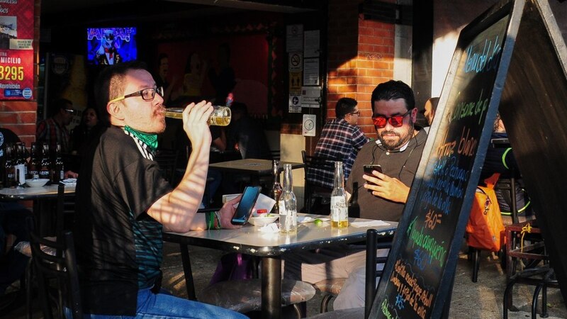 Dos hombres tomando cerveza en un bar