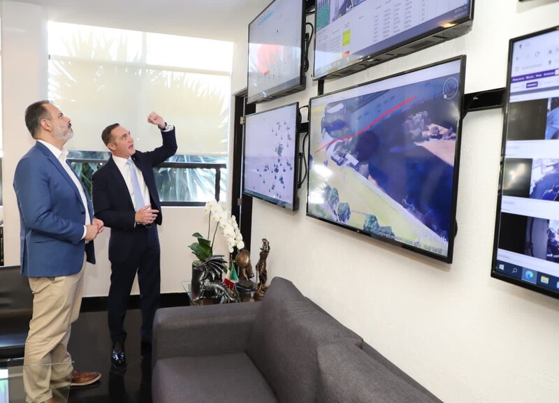Dos hombres observan una pantalla en la que se muestra un mapa.