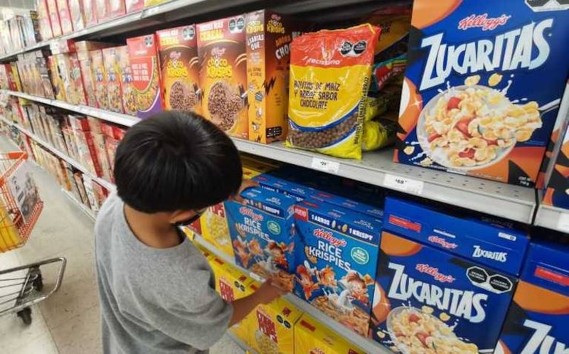 Niño elige una caja de cereal en el supermercado