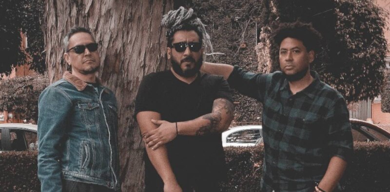 Tres hombres sonríen a la cámara