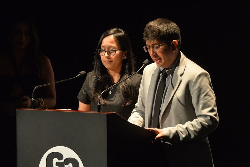 Dos jóvenes dan un discurso en un podio.
