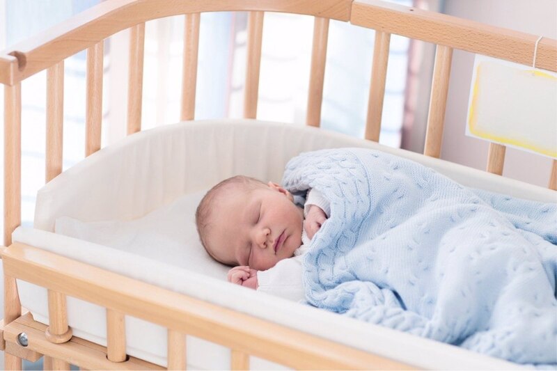 Bebé recién nacido durmiendo en una cuna