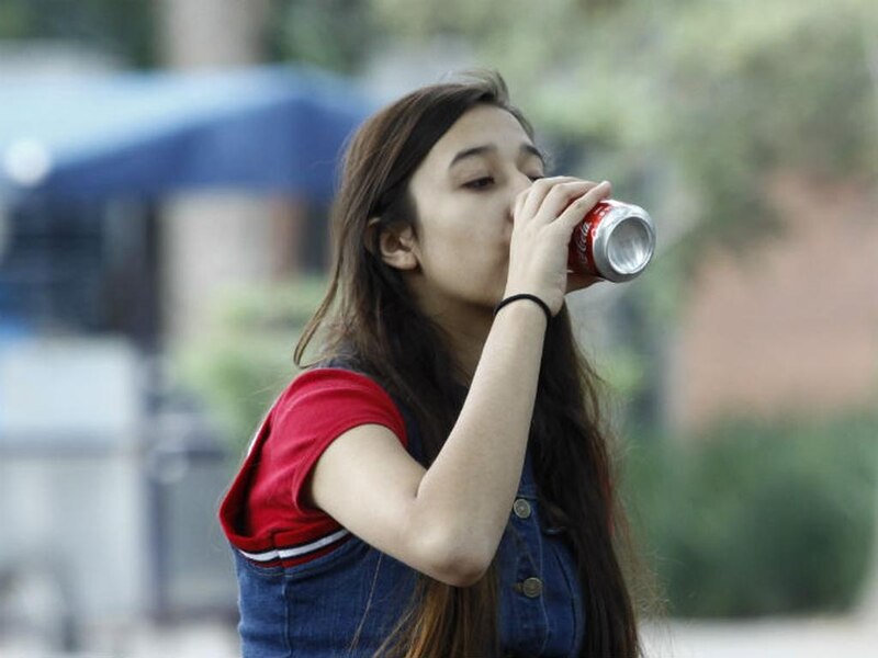 Jovencita bebiendo una Coca-Cola