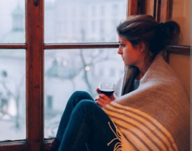 Mujer triste mirando por la ventana