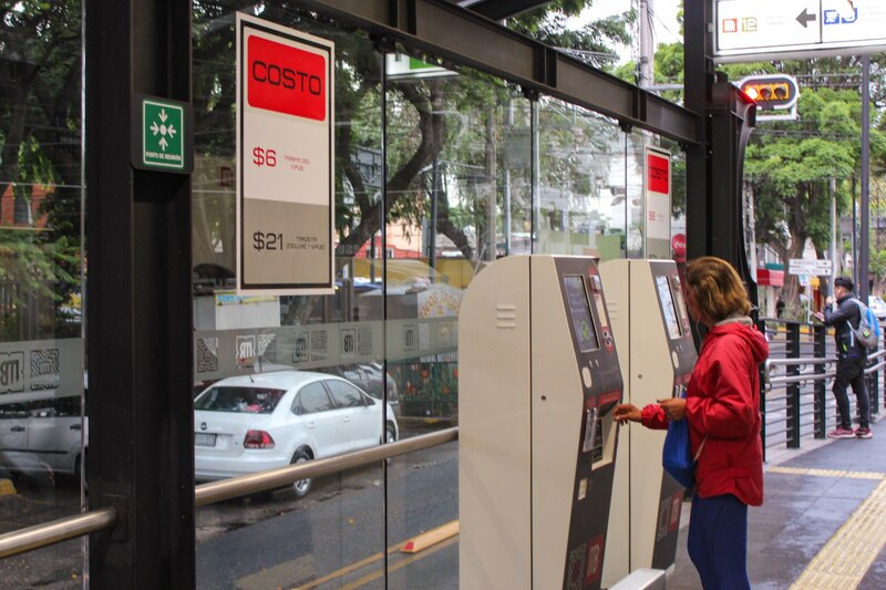 Mujer usando una máquina expendedora de billetes