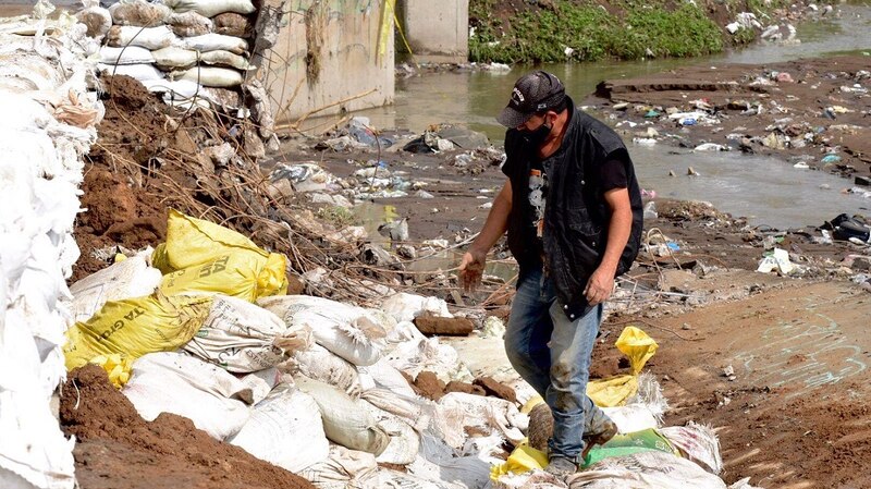 Un hombre camina sobre un montón de escombros