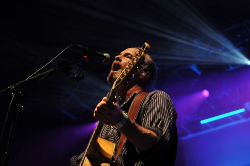 Un músico tocando la guitarra en un concierto