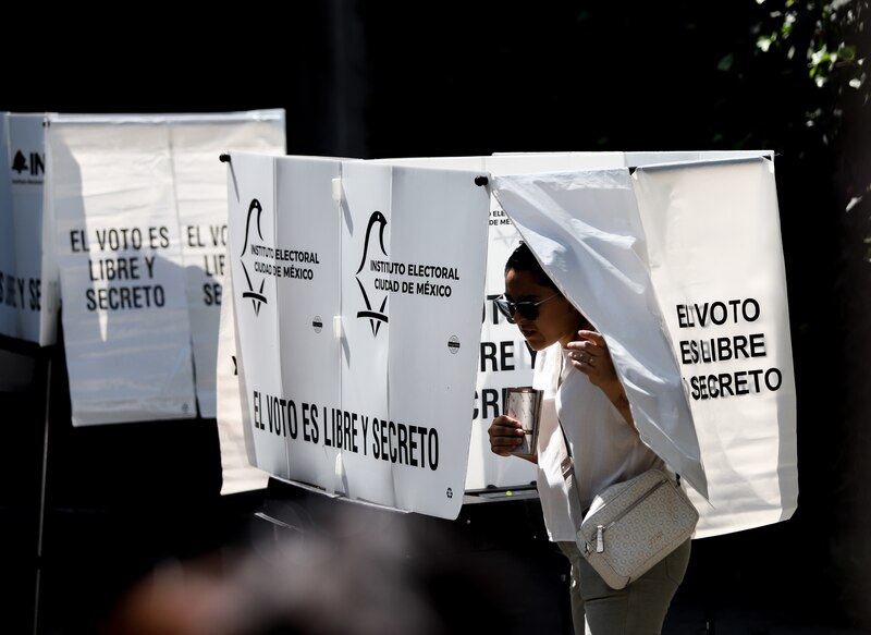 Mujer emite su voto en una casilla electoral