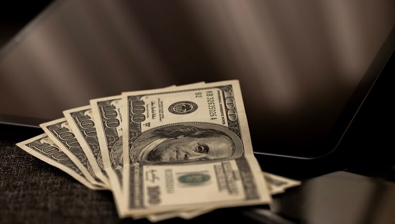 Dinero en efectivo sobre una computadora portátil