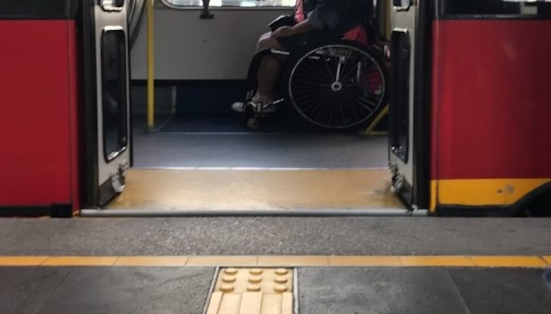 Persona usuaria de silla de ruedas aborda unidad de transporte público accesible