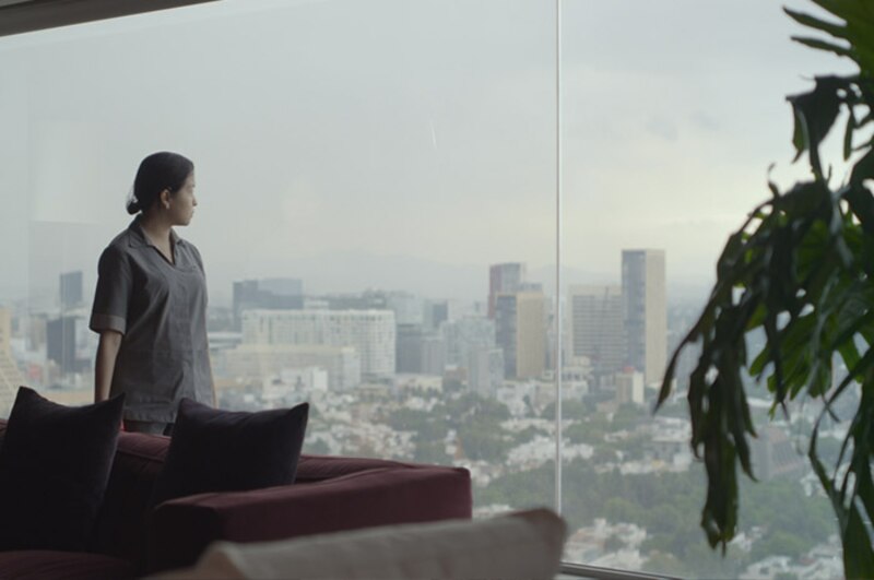 Mujer mirando por la ventana de un rascacielos