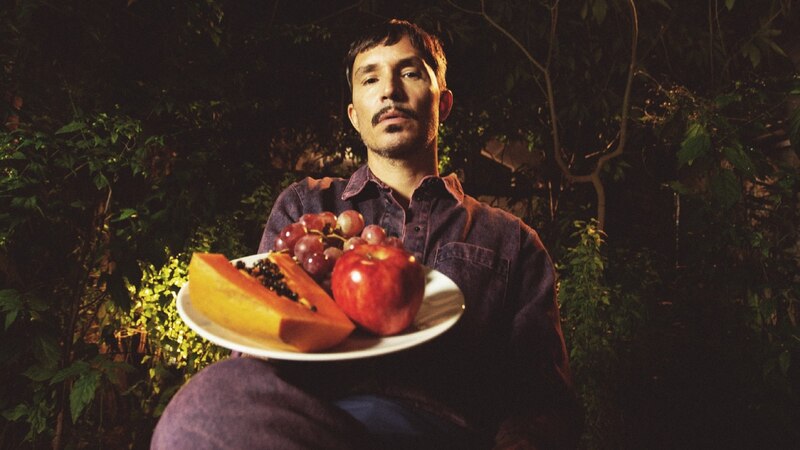 Un hombre sostiene una bandeja con frutas