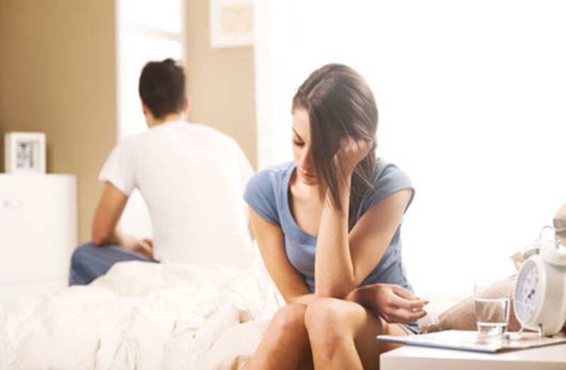Mujer triste sentada en la cama