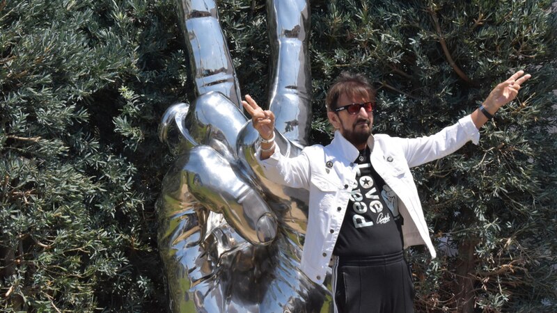 El cantante Miguel Bosé muestra el símbolo de la paz