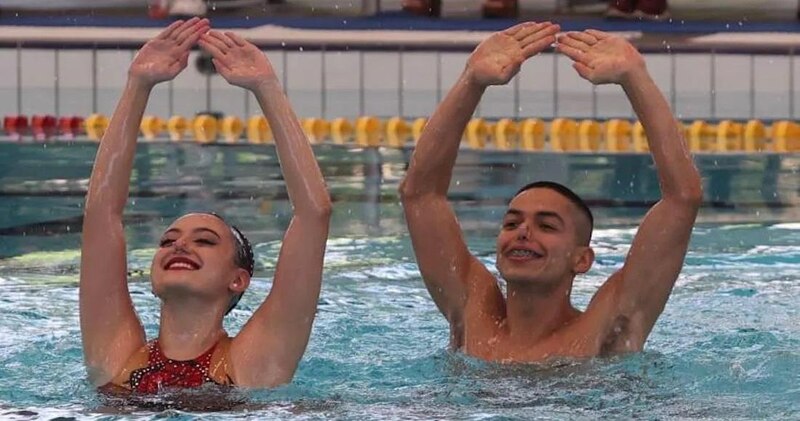 Nadadores sincronizados realizan una rutina en el agua