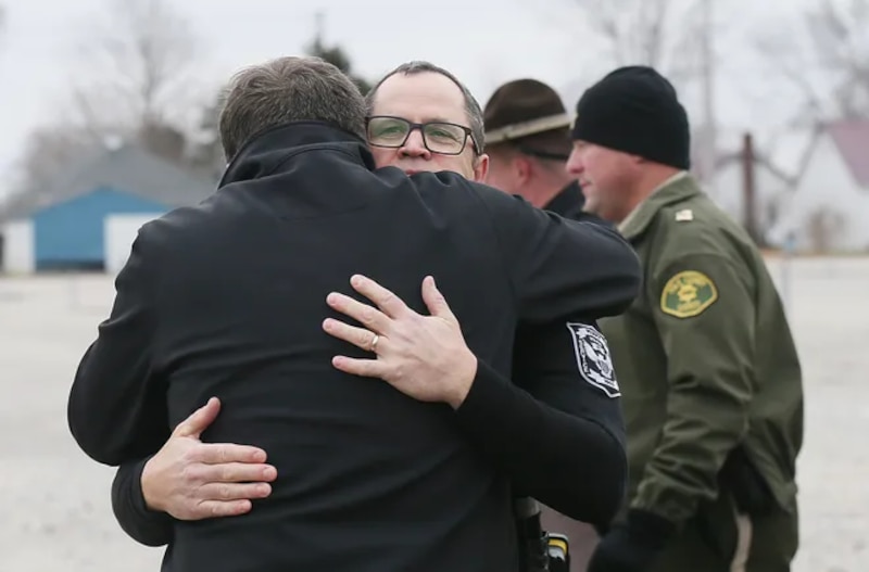 Policía abraza a un hombre