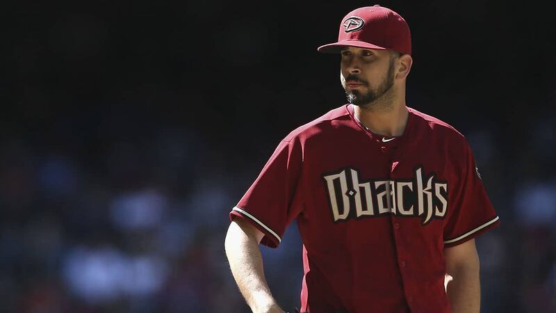 El lanzador de los Diamondbacks, Madison Bumgarner, observa el juego desde el montículo.