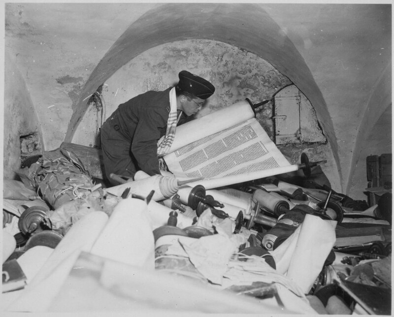 Un hombre lee un rollo de la Torá en una cueva.