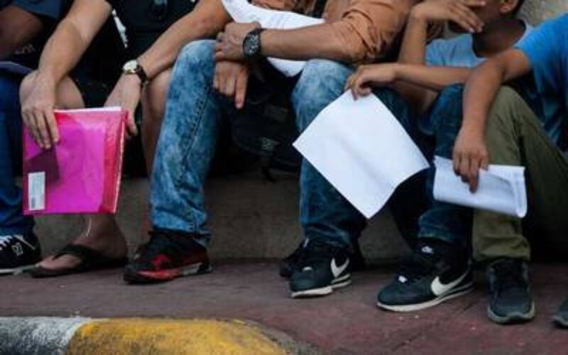 Jóvenes migrantes esperan su destino en la frontera
