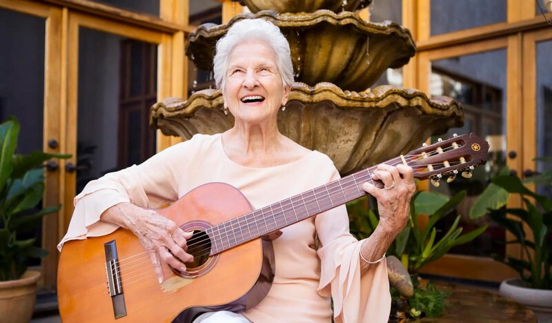 Mujer mayor tocando la guitarra