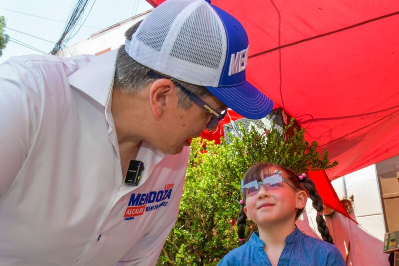 El candidato Luis Mendoza saluda a una niña durante su campaña electoral