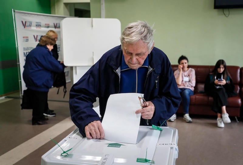 Un hombre de edad avanzada deposita su voto en una urna durante las elecciones en Rusia