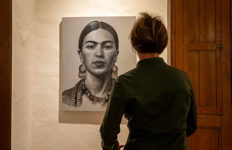 Mujer mirando un cuadro de Frida Kahlo