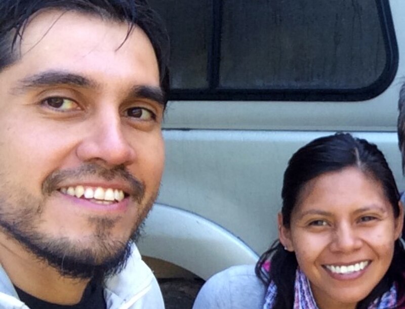 Sonriente pareja de excursionistas en la cima de una montaña