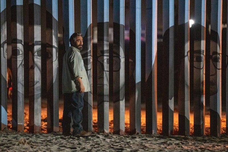 Un hombre mirando un mural de escritores famosos