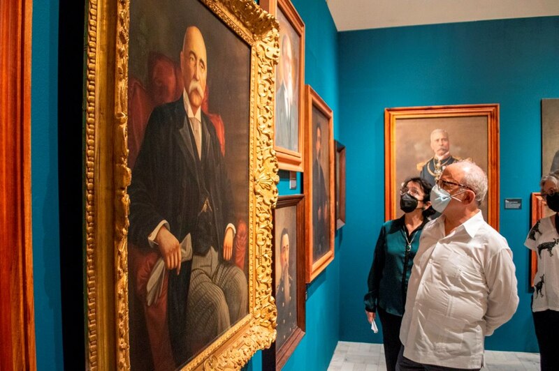 Visitantes admirando un retrato de Porfirio Díaz en el Museo Nacional de Historia