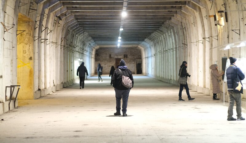Un grupo de personas camina por un túnel subterráneo.